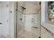 Modern shower featuring glass doors, multiple shower heads, and tile and pebble accents at 1692 Sand Lily Dr, Golden, CO 80401