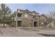 Inviting exterior showcasing stone accents, a private balcony, and ample parking in front of the building at 7440 S Blackhawk St # 15-202, Englewood, CO 80112