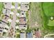Aerial view of neighborhood homes, with one featuring solar panels, near a lush green golf course at 27196 E Alder Dr, Aurora, CO 80016