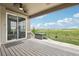 Covered back porch with a view of open space, hot tub, and sliding glass door at 27196 E Alder Dr, Aurora, CO 80016