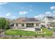Well-maintained backyard with a covered patio, solar panels, hot tub, and manicured lawn at 27196 E Alder Dr, Aurora, CO 80016