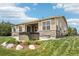 Well-maintained backyard featuring hot tub, patio, stone accents, and tasteful landscaping at 27196 E Alder Dr, Aurora, CO 80016