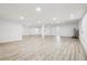 Spacious basement with light wood-look flooring, recessed lighting, and plenty of open space at 27196 E Alder Dr, Aurora, CO 80016