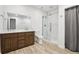 Modern bathroom with wood look floors, double vanity, glass enclosed shower, and white subway tile at 27196 E Alder Dr, Aurora, CO 80016