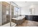 Elegant bathroom featuring a glass-enclosed shower and a luxurious soaking tub beneath a window at 27196 E Alder Dr, Aurora, CO 80016