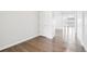 Clean hallway with hardwood floors and white walls, leading to a bright and airy living area at 27196 E Alder Dr, Aurora, CO 80016