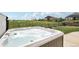 Relaxing hot tub overlooking a manicured lawn and open green space with black, wrought iron fencing at 27196 E Alder Dr, Aurora, CO 80016
