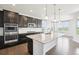 Modern kitchen boasts an island, stainless steel appliances, and sleek, dark cabinets at 27196 E Alder Dr, Aurora, CO 80016
