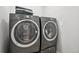 Laundry room featuring modern washer and dryer with dark gray finish at 27196 E Alder Dr, Aurora, CO 80016