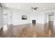 Open-concept living room featuring hardwood floors, a ceiling fan, a fireplace, and a wall-mounted TV at 27196 E Alder Dr, Aurora, CO 80016