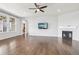 Open-concept living room with hardwood floors, fireplace, ceiling fan, and natural light at 27196 E Alder Dr, Aurora, CO 80016