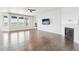 Bright living room with hardwood floors, a fireplace, ceiling fan, and large windows for ample light at 27196 E Alder Dr, Aurora, CO 80016
