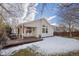 House back exterior with deck, snow-covered yard, and wooden fence at 5935 E 129Th Pl, Thornton, CO 80602