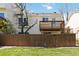 A fenced backyard with green grass is overlooked by a second-story deck at 7722 S Steele St, Centennial, CO 80122