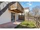 A backyard with a small patio, wooden fence, and second-story deck provides a private outdoor space at 7722 S Steele St, Centennial, CO 80122