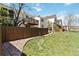 A fenced-in backyard with green grass and walkway offer space to enjoy the outdoors at 7722 S Steele St, Centennial, CO 80122