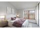 Bedroom featuring a large window with natural light, soft carpet, and modern decor at 7722 S Steele St, Centennial, CO 80122