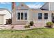 A charming home exterior with light siding, manicured landscaping, and a brick chimney at 7722 S Steele St, Centennial, CO 80122