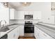 Kitchen with stainless steel appliances, white cabinets, granite counters, and ample natural light at 7722 S Steele St, Centennial, CO 80122