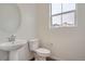 Clean bathroom with pedestal sink, toilet, and a window at 14556 W 91St Ave # A, Arvada, CO 80005