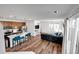 Open-concept living room boasts hardwood floors, stylish seating, and a modern kitchen with bar seating at 28304 E 6Th Pl, Watkins, CO 80137