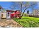 Backyard features a charming red shed with a staircase and green lawn at 6434 S Dudley Way, Littleton, CO 80123
