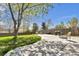 Spacious backyard featuring a large patio area, lush lawn, and mature trees, ideal for outdoor gatherings at 6434 S Dudley Way, Littleton, CO 80123