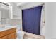 Cozy bathroom featuring a shower with a blue curtain, a classic vanity, and tiled flooring for a clean look at 6434 S Dudley Way, Littleton, CO 80123
