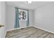 Bedroom features a window with blue curtains and hardwood flooring at 6434 S Dudley Way, Littleton, CO 80123