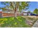 Charming single-Gathering home featuring a brick facade, well-manicured lawn, and mature shade tree at 6434 S Dudley Way, Littleton, CO 80123