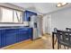 Bright kitchen features blue cabinets, stainless steel refrigerator, and hardwood floors at 6434 S Dudley Way, Littleton, CO 80123