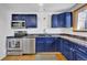 Modern kitchen features navy cabinetry, stainless steel appliances and updated fixtures at 6434 S Dudley Way, Littleton, CO 80123