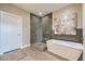 Modern bathroom with a glass-enclosed shower, soaking tub, and sleek gray tile at 6849 E Lowry Blvd, Denver, CO 80230