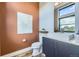 Chic powder room with stylish vanity, sleek sink, granite counters, designer mirror, and unique wall art at 6849 E Lowry Blvd, Denver, CO 80230