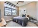 Cozy bedroom featuring a large window, neutral tones, comfortable bedding, and minimalist decor at 6849 E Lowry Blvd, Denver, CO 80230