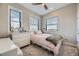 Inviting bedroom with a twin bed, neutral decor, ceiling fan, dresser, and ample natural light at 6849 E Lowry Blvd, Denver, CO 80230