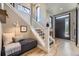 Light-filled entryway featuring hardwood floors, white staircase, and a gray bench at 6849 E Lowry Blvd, Denver, CO 80230