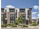 Modern townhome featuring brick and siding with large windows and manicured landscaping at 6849 E Lowry Blvd, Denver, CO 80230