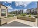 View of modern townhomes with well-maintained landscaping and a concrete patio at 6849 E Lowry Blvd, Denver, CO 80230