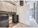 Modern laundry room featuring front loading washer/dryer, storage and easy access to a hallway at 6849 E Lowry Blvd, Denver, CO 80230