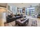 Open-concept living room featuring large windows, a sectional sofa, and hardwood floors at 6849 E Lowry Blvd, Denver, CO 80230