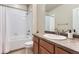 Well-lit bathroom with a shower-tub combo and a vanity with sink and dark wood cabinetry at 555 Gallegos Cir, Erie, CO 80516