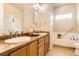 Inviting bathroom featuring dual sinks, a vanity and a soaking tub, with a minimalist design at 555 Gallegos Cir, Erie, CO 80516