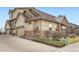 Exterior view of a townhome featuring a two-car garage, and well-kept landscaping at 555 Gallegos Cir, Erie, CO 80516