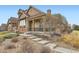 Attractive home exterior with stone accents, covered porch, and well-maintained landscaping at 555 Gallegos Cir, Erie, CO 80516