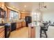 Well-lit kitchen with stainless steel appliances, center island with bar seating, flowing into an open living space at 555 Gallegos Cir, Erie, CO 80516