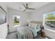A well lit bedroom with two windows featuring a ceiling fan and view of yard at 1335 N Alton St, Aurora, CO 80010