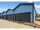Brand new garages for the townhomes with dark gray doors and light blue siding at 1335 N Alton St, Aurora, CO 80010