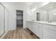 Bathroom with a double sink vanity, a large mirror, and a walk-in closet at 2887 E 103Rd Dr, Thornton, CO 80229