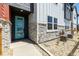 Inviting townhome entryway with a modern turquoise door, stone accents, and low-maintenance landscaping at 2887 E 103Rd Dr, Thornton, CO 80229